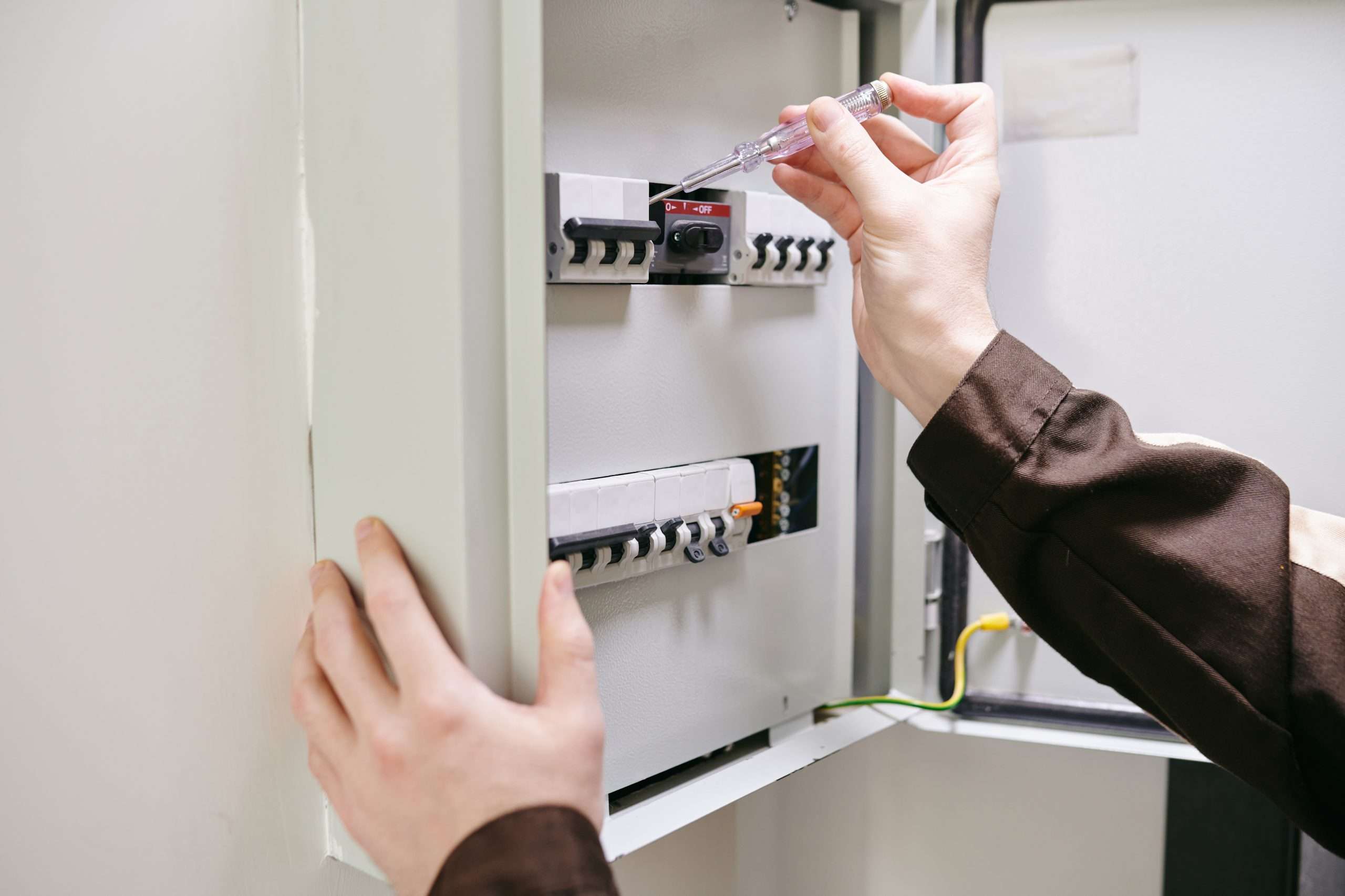 Hands of young electrician using current measuring tool